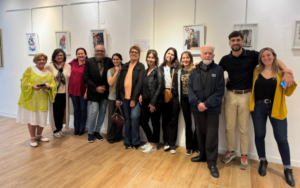 Artistas posan ante cuadros de arte en Casa de Entre Ríos.