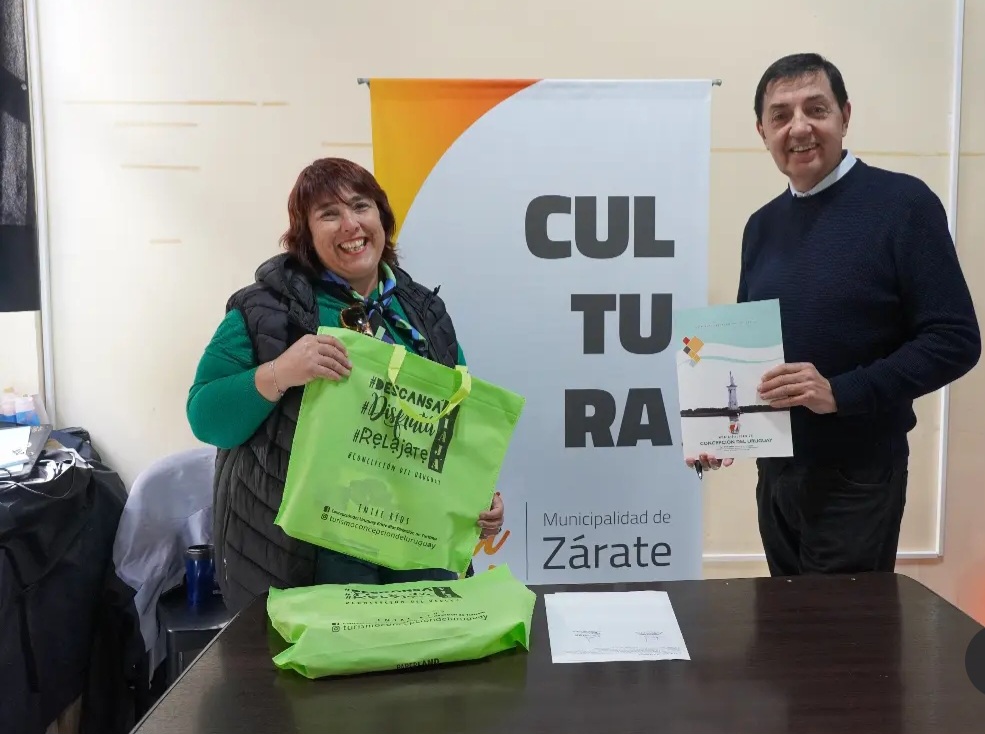 La Directro da Turismo de Concepción del Uruguay posa junto a su equipo ofrece alfajores de la ciudad.