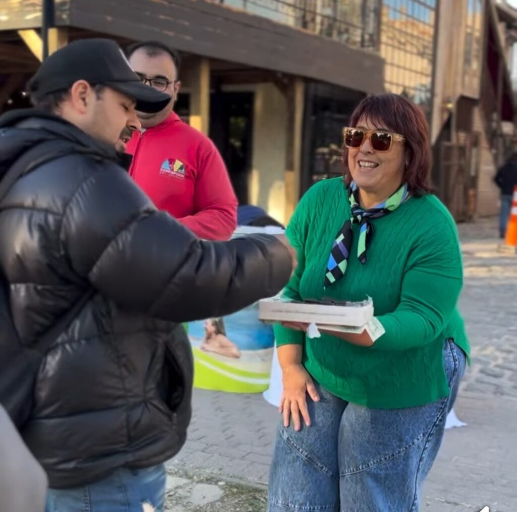 La Directro da Turismo de Concepción del Uruguay junto a su equipo ofrece alfajores de la ciudad.
